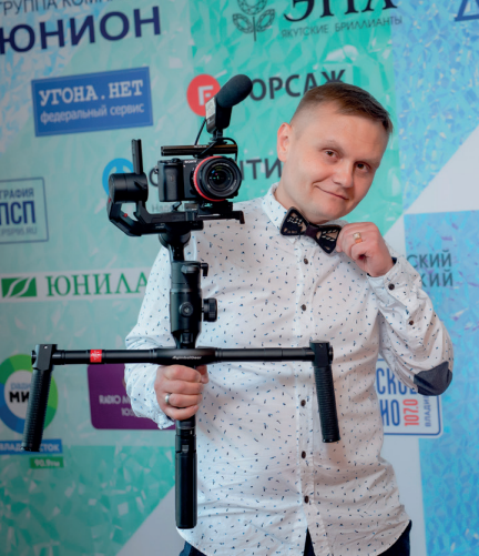 Михаил Морозов с камерой на стабилизаторе на деловом мероприятии